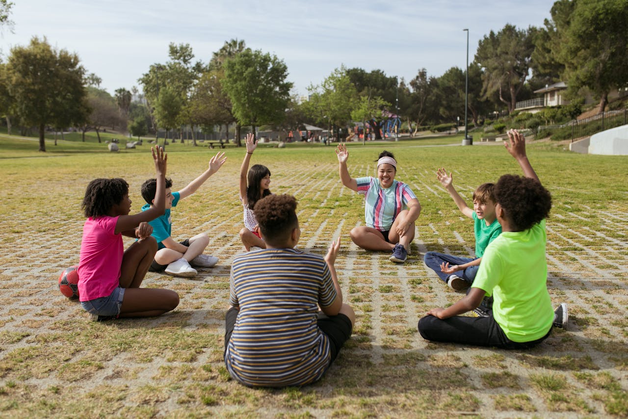 A group of kids having fun playing games together in a sunny park setting.